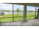 Screened in patio with brick floor and a view of the lawn and lake at 2612 Summer Clouds Way, Kissimmee, FL 34744