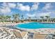 Resort-style pool area with lounge chairs, palm trees, and a clubhouse in the background at 2612 Summer Clouds Way, Kissimmee, FL 34744