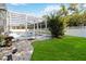 Backyard area including a screened pool, green lawn, garden areas, and a privacy fence at 2865 Ashton Ter, Oviedo, FL 32765