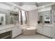 Bathroom featuring dual vanities, corner soaking tub, decorative mirrors, and a separate shower at 2865 Ashton Ter, Oviedo, FL 32765