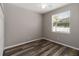 Bedroom with wood floors, neutral paint, white trim, and a large window with mini-blinds at 2865 Ashton Ter, Oviedo, FL 32765
