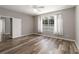 Bedroom with wood floors, neutral paint, ceiling fan, and large window overlooking a fenced backyard and pool at 2865 Ashton Ter, Oviedo, FL 32765