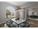 Dining room with a modern light fixture, a marble table and a view to the living room at 2865 Ashton Ter, Oviedo, FL 32765