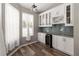 Kitchen nook featuring white cabinets, glass shelving, a wine cooler, and view to the pool at 2865 Ashton Ter, Oviedo, FL 32765
