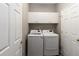 Functional laundry room with storage cabinets, modern washer and dryer units, and white doors at 2865 Ashton Ter, Oviedo, FL 32765