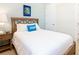 Bedroom with a wooden bed frame, a blue accent pillow, and neutral wall color at 3004 Latitude Ln, Kissimmee, FL 34747
