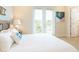 Bright bedroom featuring a balcony, cozy bedding, and a beach-themed decorative pillow at 3004 Latitude Ln, Kissimmee, FL 34747