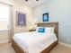 Cozy bedroom features a wooden bed frame, tile flooring, and a bright window at 3004 Latitude Ln, Kissimmee, FL 34747