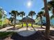 Charming community featuring a central tiki hut, colorful homes, and lush palm tree landscaping at 3004 Latitude Ln, Kissimmee, FL 34747