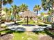 A tranquil tiki hut sits in the community area, surrounded by palm trees and colorful Margaritaville homes at 3004 Latitude Ln, Kissimmee, FL 34747