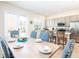 Bright dining area with a wooden table set for a meal, and kitchen in the background at 3004 Latitude Ln, Kissimmee, FL 34747