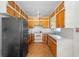 A kitchen with wooden cabinets, appliances, and a ceiling fan in need of renovation at 321 Beard Rd, Winter Garden, FL 34787