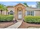 Inviting front entrance with stone archway and manicured landscaping at 335 Oakpark Loop, Davenport, FL 33837