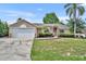 Charming single-story home features a stone-accented facade and a well-maintained lawn at 335 Oakpark Loop, Davenport, FL 33837