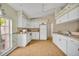 Bright kitchen with ample white cabinetry, laminate floors and natural light from the large window at 335 Oakpark Loop, Davenport, FL 33837