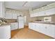 Spacious kitchen features white cabinetry, laminate floors, and plenty of natural light at 335 Oakpark Loop, Davenport, FL 33837