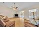 Spacious living room with light hardwood floors, fan, and sliding glass doors at 335 Oakpark Loop, Davenport, FL 33837