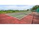 Exterior view of a neighborhood tennis court with a red and green surface, perfect for recreational activities at 335 Oakpark Loop, Davenport, FL 33837