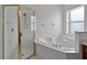 Bright bathroom featuring a glass shower, tub, and window at 3533 Somerset Cir, Kissimmee, FL 34746