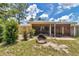 Exterior view of home's backyard featuring a fire pit, patio, and lawn at 37 Pecan Pass Trl, Ocala, FL 34472