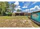 Expansive backyard featuring a screened-in porch, fire pit area, and a unique Margaritaville-themed shed, perfect for entertaining at 37 Pecan Pass Trl, Ocala, FL 34472