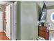 Entryway hallway with hardwood flooring, doors leading to bedrooms, and a TV at 37 Pecan Pass Trl, Ocala, FL 34472