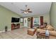 Spacious living room with tile floors, a ceiling fan, and large windows for natural light at 37 Pecan Pass Trl, Ocala, FL 34472