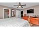 Comfortable main bedroom with a ceiling fan, wood-look floors, and easy access to the ensuite bathroom at 37 Pecan Pass Trl, Ocala, FL 34472