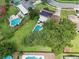 Aerial view highlights lush greenery, a sparkling pool, and solar panels on the roof at 4536 Misty Morn Cir, Orlando, FL 32812