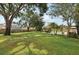 Expansive backyard with lush green lawn, mature trees, swimming pool, and outdoor dining area at 4536 Misty Morn Cir, Orlando, FL 32812