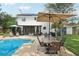 Inviting backyard with solar panels, pool, patio table and chairs, lush green lawn, and privacy fence at 4536 Misty Morn Cir, Orlando, FL 32812