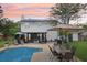 Spacious backyard with pool, patio, outdoor seating, lush greenery, and solar panels at 4536 Misty Morn Cir, Orlando, FL 32812