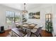 Elegant dining room with a rustic wood table, stylish chairs, bench seating, and a contemporary chandelier at 4536 Misty Morn Cir, Orlando, FL 32812