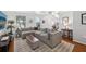 Spacious living room features hardwood floors, a comfortable gray sectional sofa, and abundant natural light, creating an inviting atmosphere at 4536 Misty Morn Cir, Orlando, FL 32812