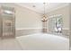 Bright dining room boasts neutral walls, plush carpet, and a stylish chandelier at 460 Suncrest Ct, Oviedo, FL 32765