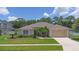 Charming single-story home featuring a well-manicured lawn and mature landscaping at 460 Suncrest Ct, Oviedo, FL 32765