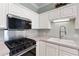 Modern kitchen boasts sleek stainless steel appliances, white cabinetry, and updated fixtures at 460 Suncrest Ct, Oviedo, FL 32765