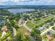 Aerial view features a house in a golf community with lake access, lush landscaping, and mature trees at 5704 Bay Side Dr, Orlando, FL 32819