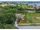 Aerial view of the property with lush landscaping, a pond and a glimpse of the lake in the background at 5704 Bay Side Dr, Orlando, FL 32819