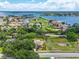 Ariel view of the property with lush landscaping with water views and neighboring homes in the background at 5704 Bay Side Dr, Orlando, FL 32819
