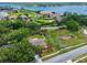 Aerial view of property surrounded by lush trees and green space with a glimpse of lake in background at 5704 Bay Side Dr, Orlando, FL 32819