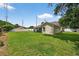 Wide, grassy backyard with a partial view of the home's exterior and a white fence at 5704 Bay Side Dr, Orlando, FL 32819