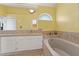 Bright bathroom featuring a soaking tub, white cabinetry, and neutral countertops at 5704 Bay Side Dr, Orlando, FL 32819
