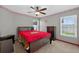 Spacious bedroom with a red and brown bedspread, ceiling fan and Buckeye themed decor at 5704 Bay Side Dr, Orlando, FL 32819