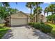 A single-story home featuring a driveway and lush, green landscaping at 5704 Bay Side Dr, Orlando, FL 32819