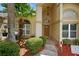 Covered front entryway surrounded by lush landscaping and mulched flowerbeds at 5704 Bay Side Dr, Orlando, FL 32819