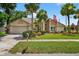 Inviting home featuring palm trees, lush landscaping, and a charming American flag at 5704 Bay Side Dr, Orlando, FL 32819