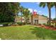 Charming home with well-manicured landscaping, palm trees, and an Ohio State flag at 5704 Bay Side Dr, Orlando, FL 32819