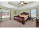 A spacious main bedroom featuring large windows, tray ceiling, and a luxurious, decorative bed at 5704 Bay Side Dr, Orlando, FL 32819