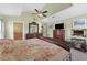 A large primary bedroom with tray ceilings, dresser, TV, and ensuite bathroom at 5704 Bay Side Dr, Orlando, FL 32819